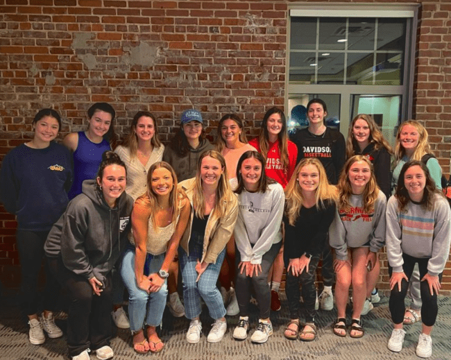 Group of women standing in front of brick wall