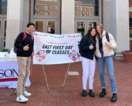 students in front of sign that reads "last first day of classes"