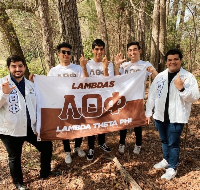 Latinx Fraternity men holding flag