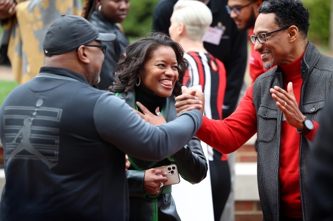 BSC celebration three people smiling and greeting each other