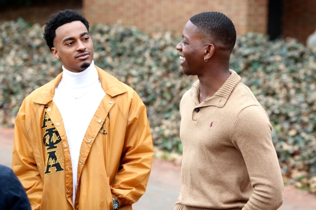 Two Black men smiling and talking to each other