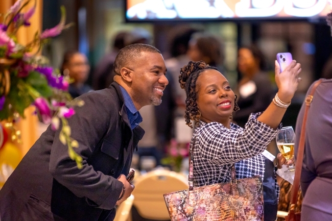 Woman holding a phone and taking a selfie with a man