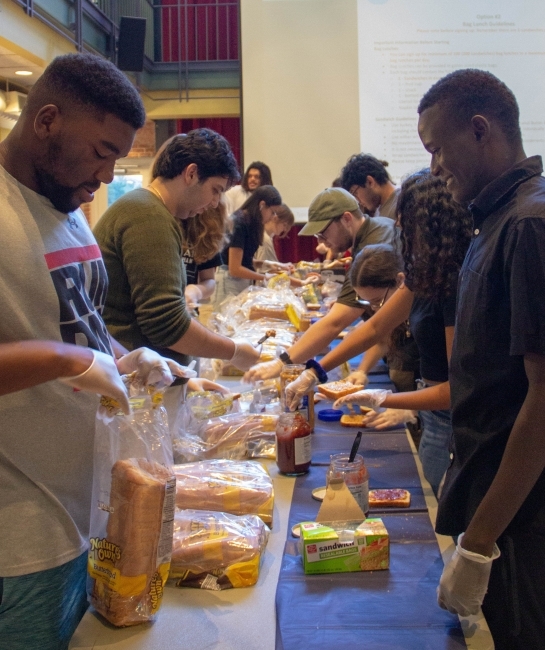 group of students around table making sandwiches