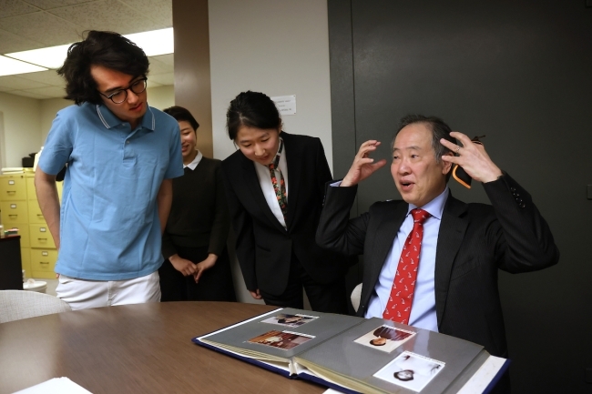 Koji Tomita '77 looking through photography from his time at Davidson