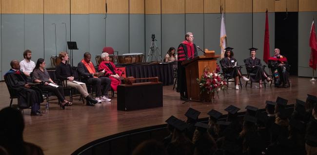 Doug Hicks at the podium onstage at Convocation