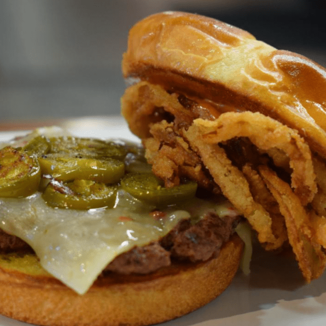 A spicy burger with crispy onions and jalapenos