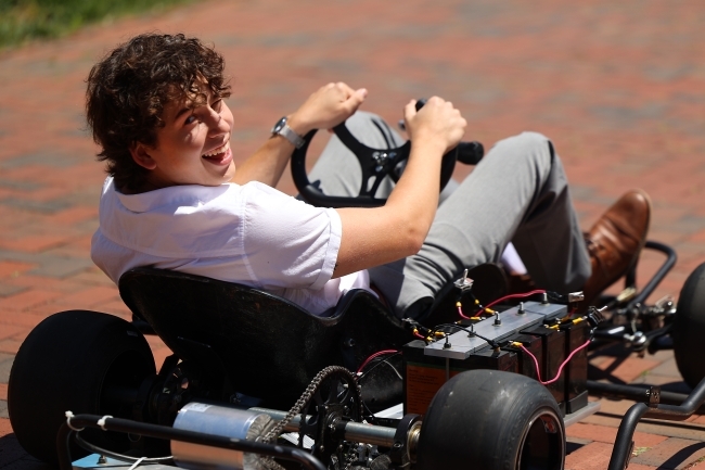 Student smiling and driving gokart