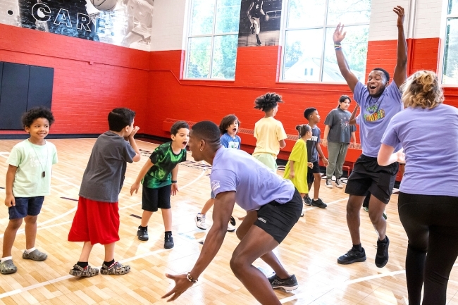 Students and kids play together in a gym