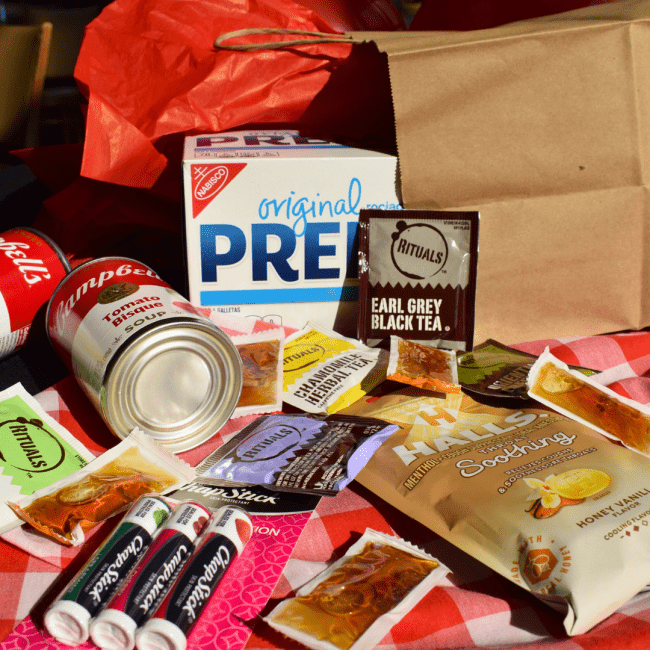 care package containing crackers, soup, tea, and chapstick