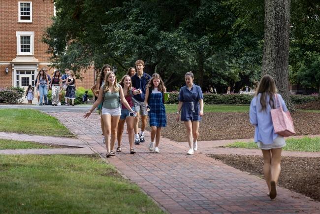 students walking and talking on campus along brick pathways