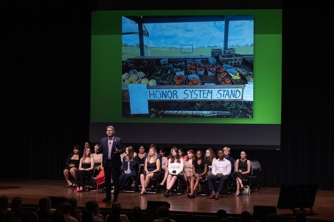 President Hicks speaks on stage as Honor Council sits behind him