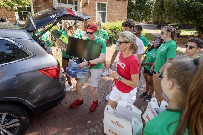 Students and parents unload a car during Move In