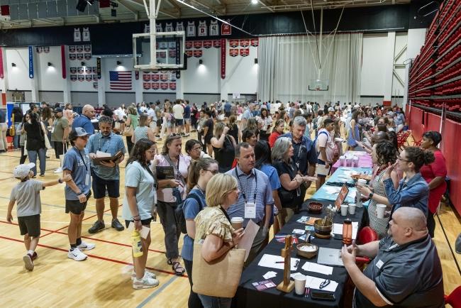 Students and their families at activities fair in gym