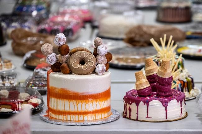 cakes decorated with donuts and ice cream cones on a table