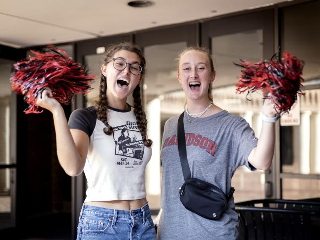 Students hold pom poms and cheer for Cake Race runners