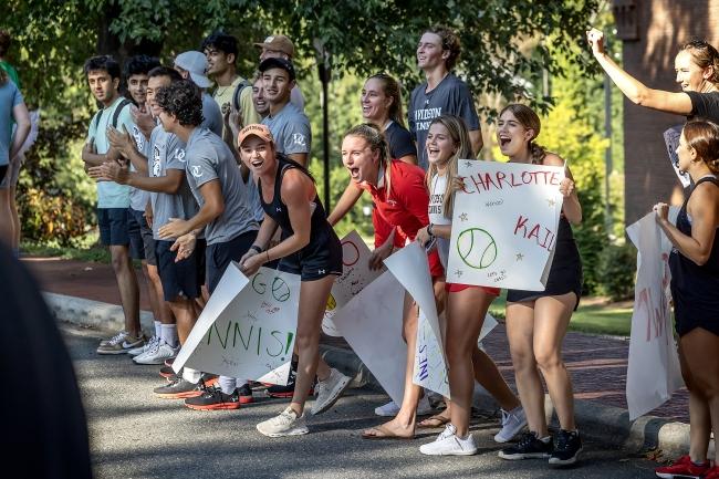 Students hold signs and cheer for runners in Cake Race
