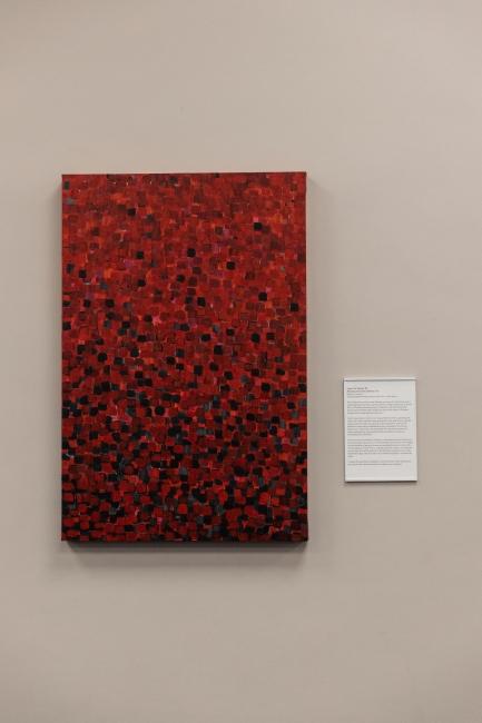 a red and black abstract artwork hanging on library wall