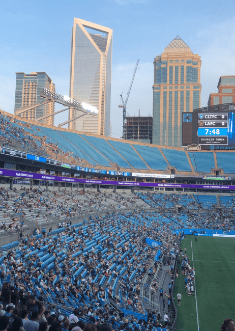 a stadium surrounded by Charlotte skyline on a sunny day