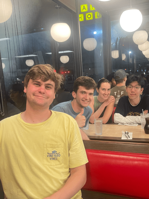 a group of students sitting together in a Waffle House booth