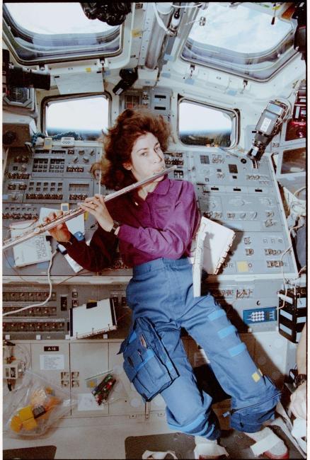 Ochoa playing the flute in space