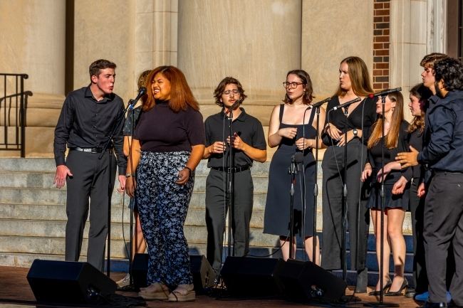 a group of students in black outfits singing