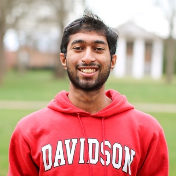 a young man wearing a red Davidson sweatshirt and smiling