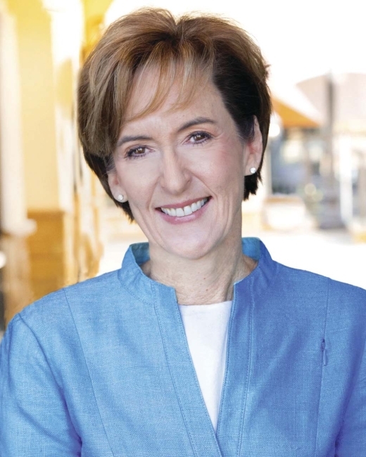 a white woman with short light brown hair wearing a blue jacket