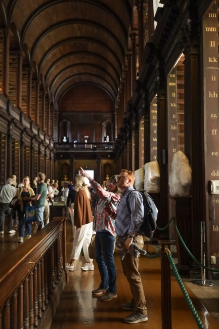 a large library with vaulted ceilings and people staring up around them