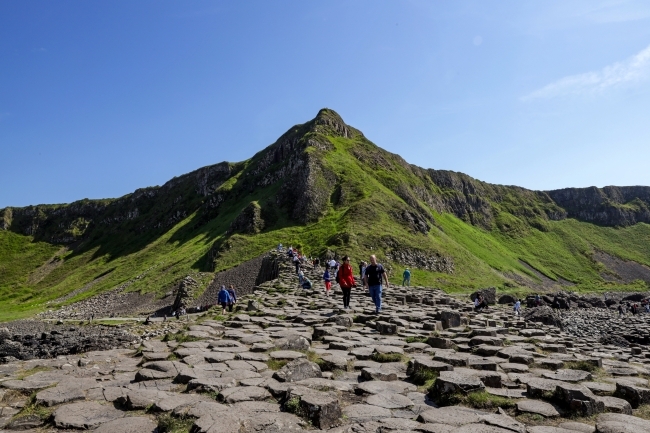 a large conical green mountain surrounded by rocks