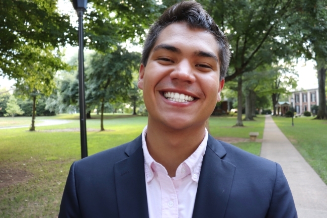 a young Asian male smiling wearing a collared shirt and jacket