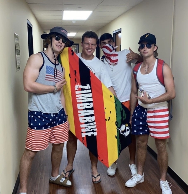 a group of young men in patriotic shorts hold a zimbabwe sign