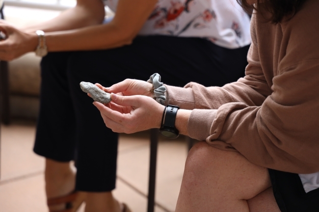 a student holds a rock while sitting in a chair