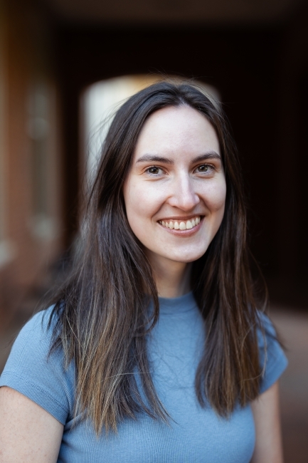 a young white woman wearing a blue blouse with brown hair