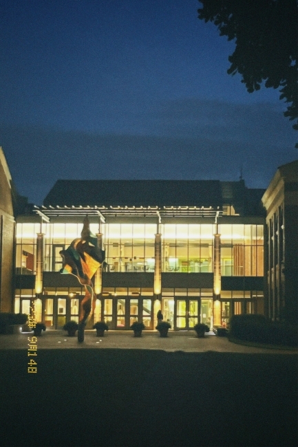 a modern academic building lit up at night