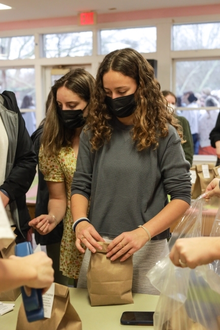 a group of two young women wrap lunch bags