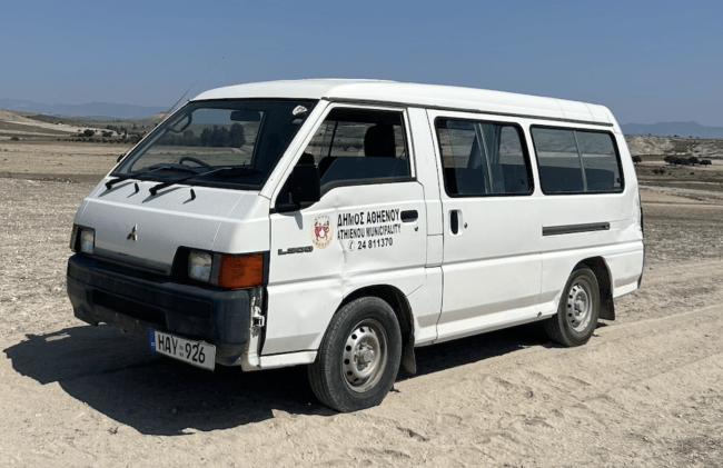 a large white van in a sandy location