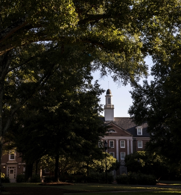 a brick columned building with trees in the foreground