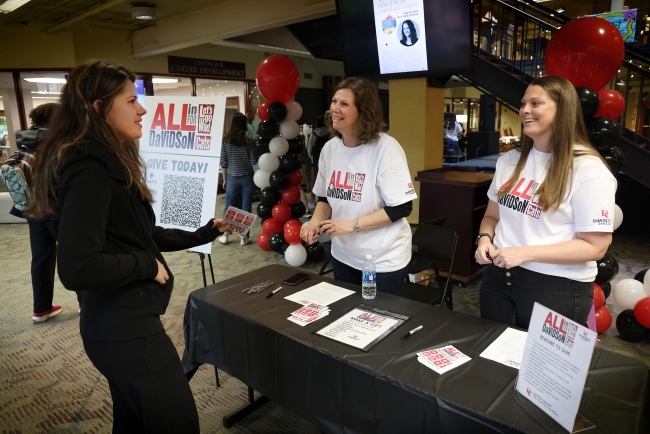 a table of two women talking to a younger woman