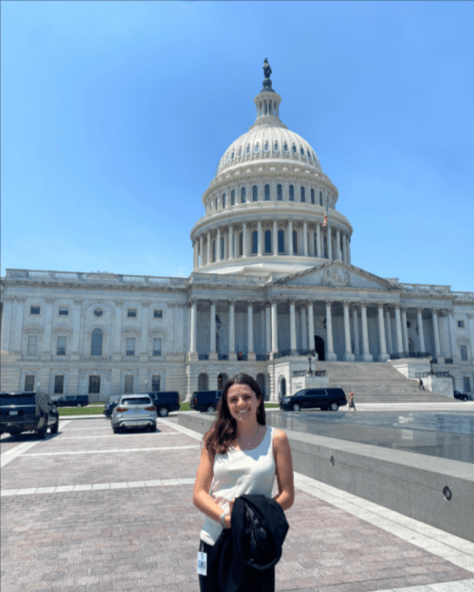 a young woman standing in front of the U.S. capitol