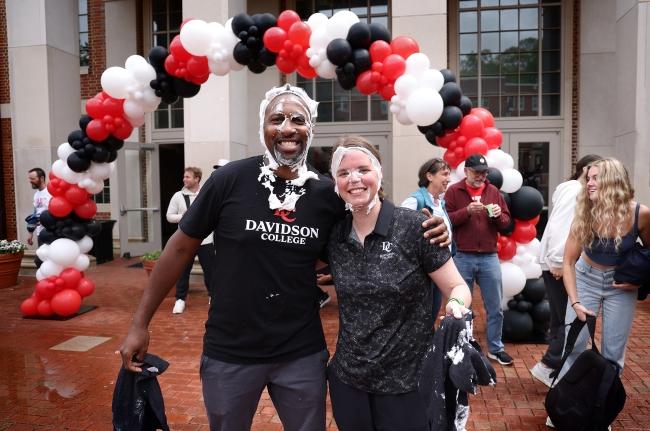 Chris Clune and other pie throwing participant under balloon arch during All In For Davidson 2024