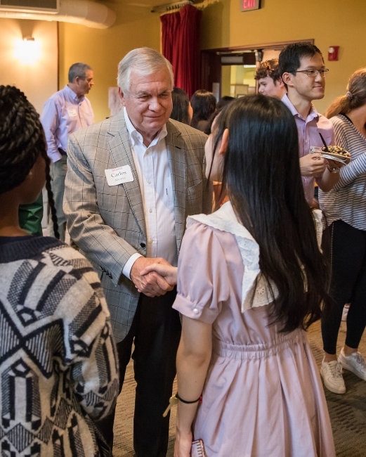 Trustee Carlos Alvarez shaking hands with a Davidson student