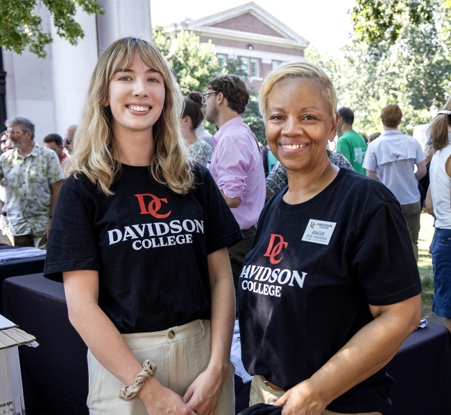 a young white woman and a middle aged Black woman stand together smiling