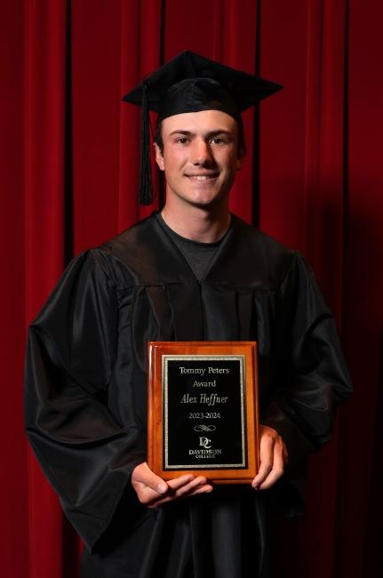 a young white man holds an award