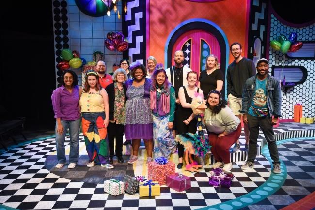 a colorful stage filled with actors and actresses in bright colors