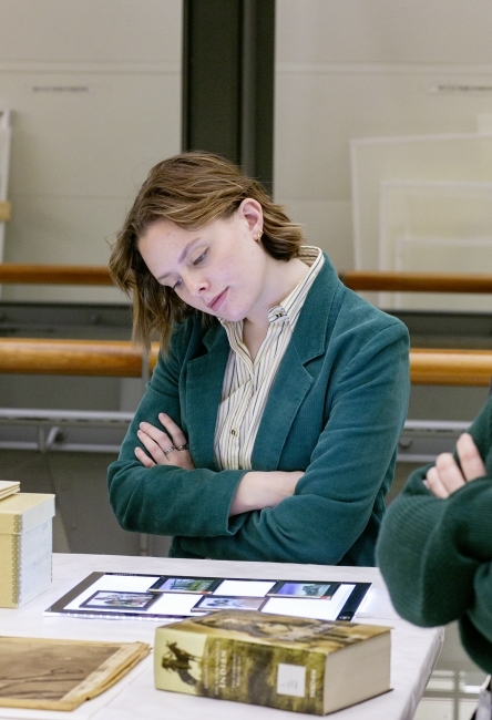 a young woman examines an archival document