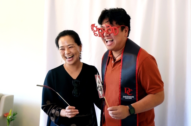 a young man and his mom smile together 