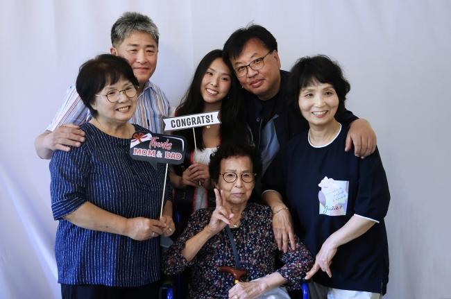 an Asian family smiles together in a photo booth