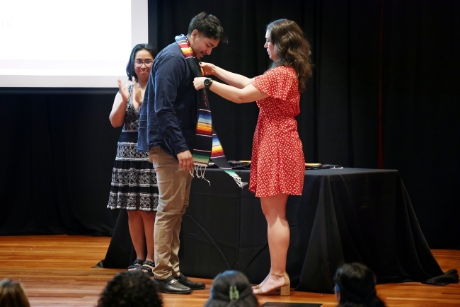 a young woman puts a cord on a young man