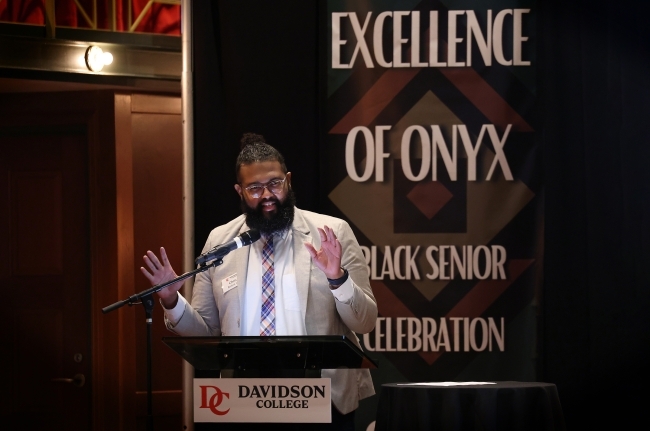 a young Black man speaks at a podium