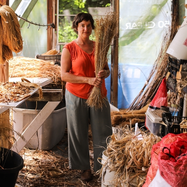 a middle aged woman holding a stack of fibers